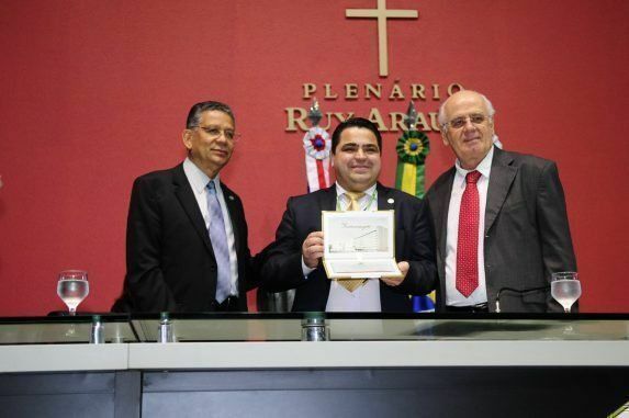 Reitor (C) recebe diploma de Honra ao Mérito pelos serviços prestados pela Biblioteconomia à sociedade. Deputados Carlos Alberto (E) e Serafim Corrêa (D). 